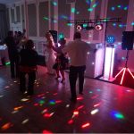 Bride and family dancing on dance floor with strobe lights